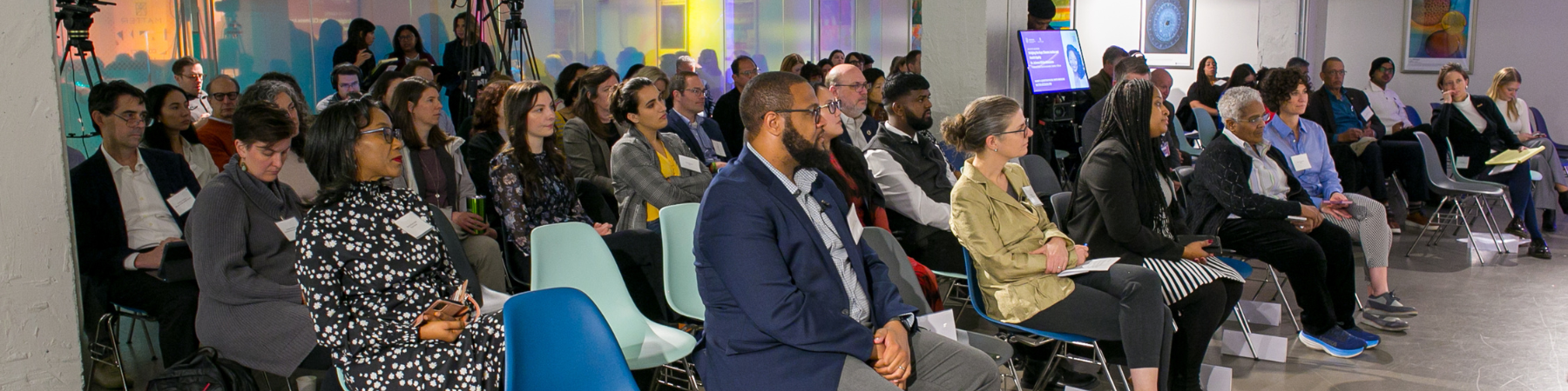 Photo of people looking straight ahead presumably at a speaker.